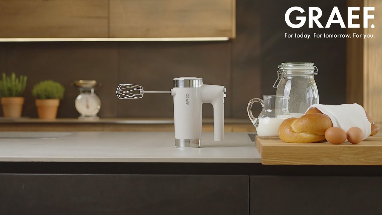Kitchen scene with hand mixer, bread, eggs, and milk. GRAEF logo.