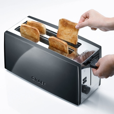 Ein Toaster mit Toastbrot, das aus dem Toaster genommen wird, Nahaufnahme.