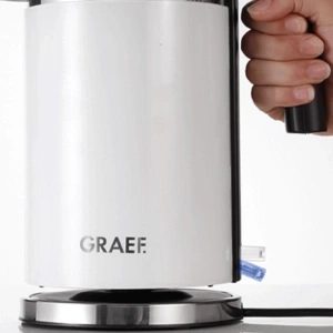 White GRAEF kettle on a silver base with a black handle, close-up shot.