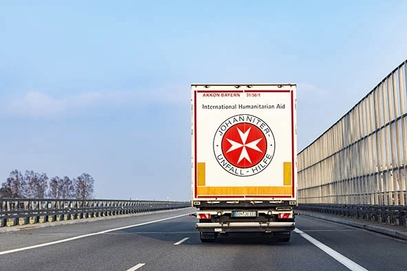 Ein LKW mit dem Logo der Johanniter-Unfall-Hilfe fährt auf der Autobahn.