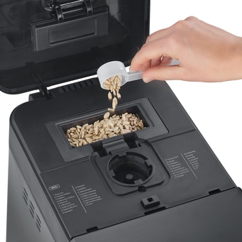 Brotbackautomat mit Zutaten, Hand, Löffel, Körner, Menü, Backen, Küche, Lebensmittel