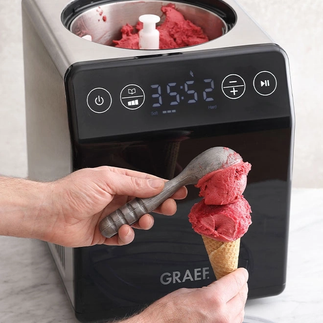 Eismaschine mit Eiscreme, die in einem Waffelkegel serviert wird, Nahaufnahme