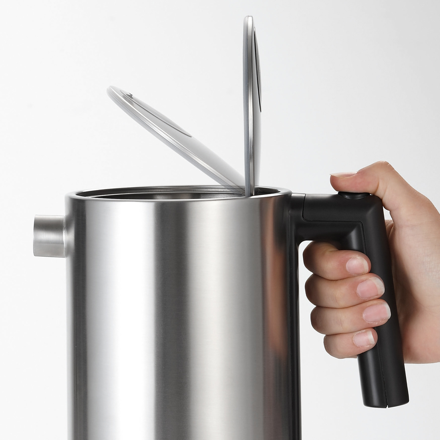 Wasserkocher mit offenem Deckel, der von einer Hand gehalten wird, Nahaufnahme