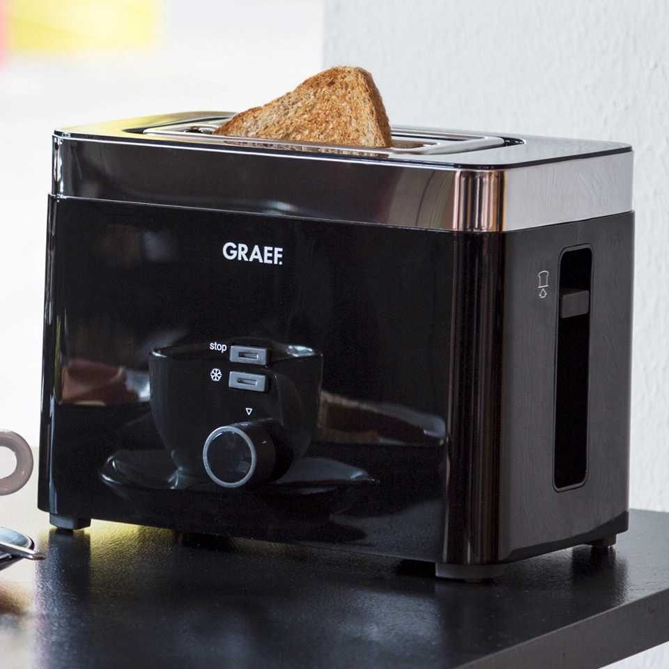 Schwarzer Toaster mit Toastbrot, Marke GRAEF, auf schwarzem Tisch