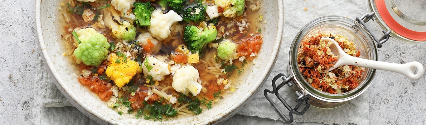 Gemüsesuppe mit Blumenkohl, Brokkoli und Gewürzen in einem Glas
