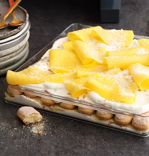 Dessert mit Mango, Sahne und Löffelbiskuits in Glasform