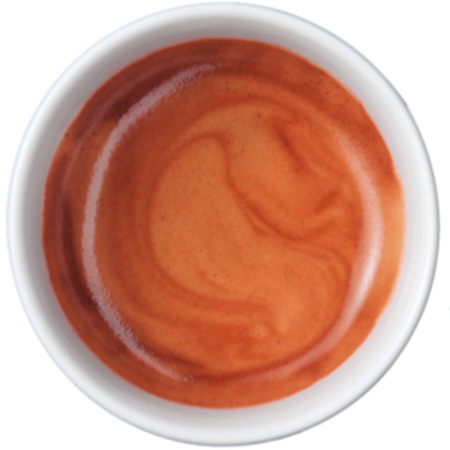 Nahaufnahme einer Tasse Espresso mit cremiger Oberfläche und Wirbeln.