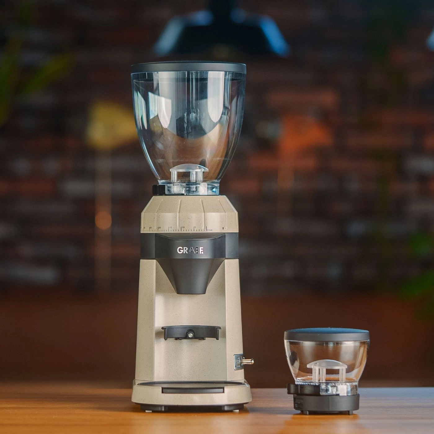 Kaffeemühle mit Behälter und Auffangbehälter auf Holzoberfläche