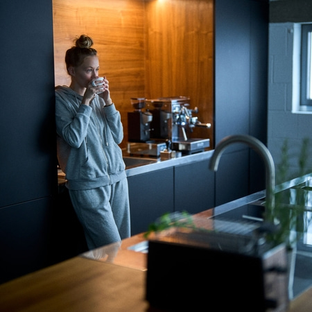 Frau trinkt Kaffee in der Küche, entspannt und genießt den Morgen