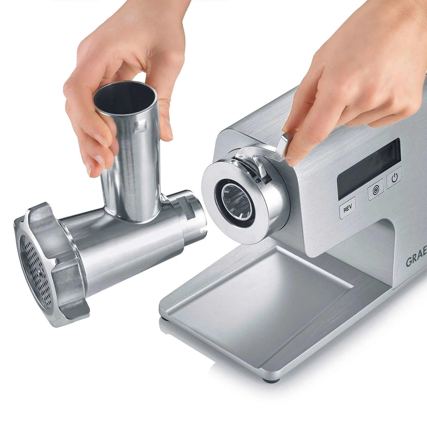 Meat grinder being assembled. Hands putting it together. Metal parts.