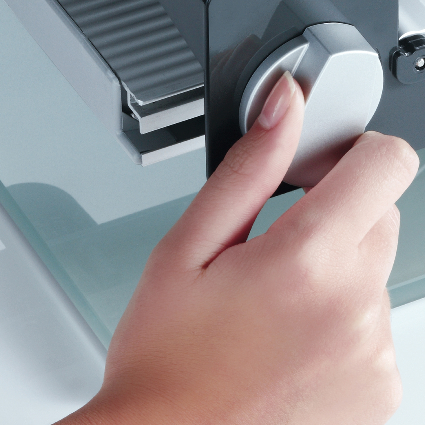 Nahaufnahme einer Hand, die einen Drehknopf an einem Gerät dreht, mit Fingernagel