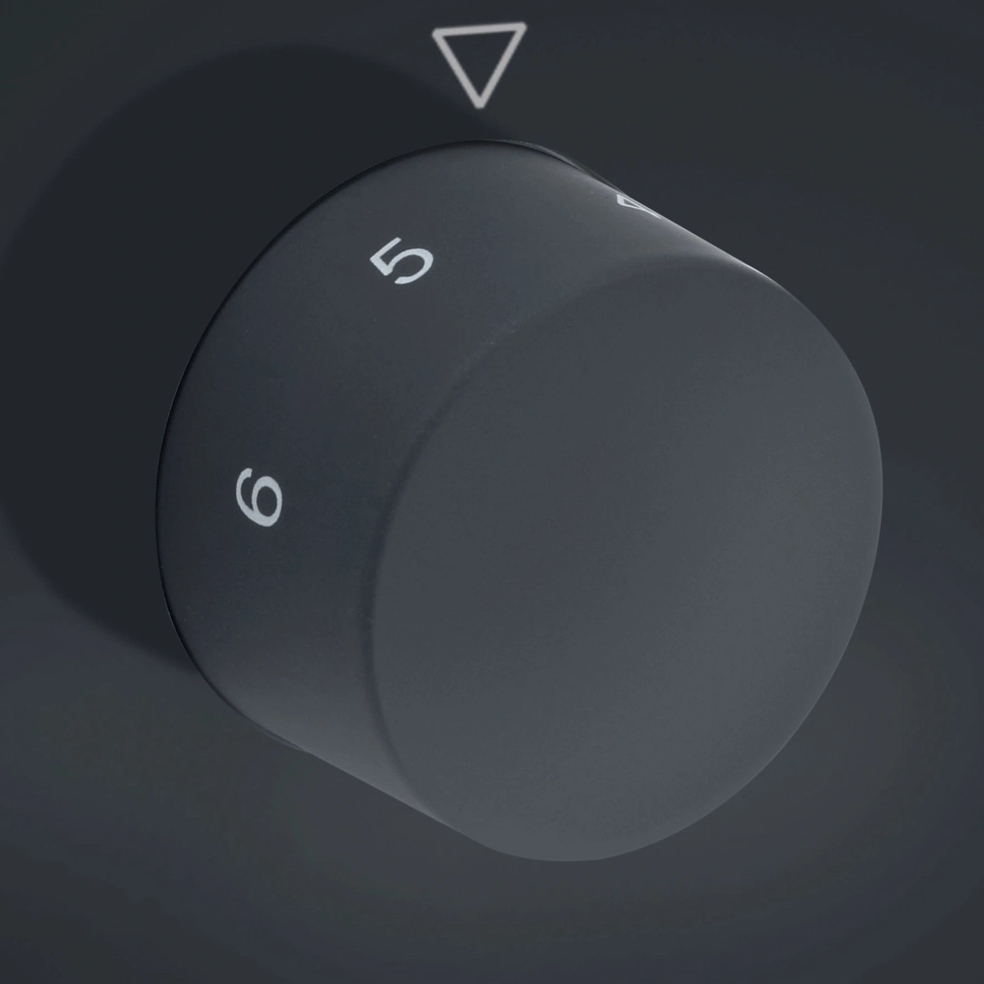 Close-up of a dark knob with numbers and a triangle indicating direction.