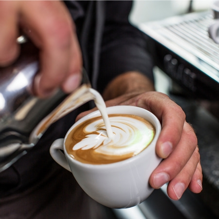 Kaffee Latte Art, Hände halten Tasse, Milch gießen, Barista-Kunst, Kaffeekunst, Getränk
