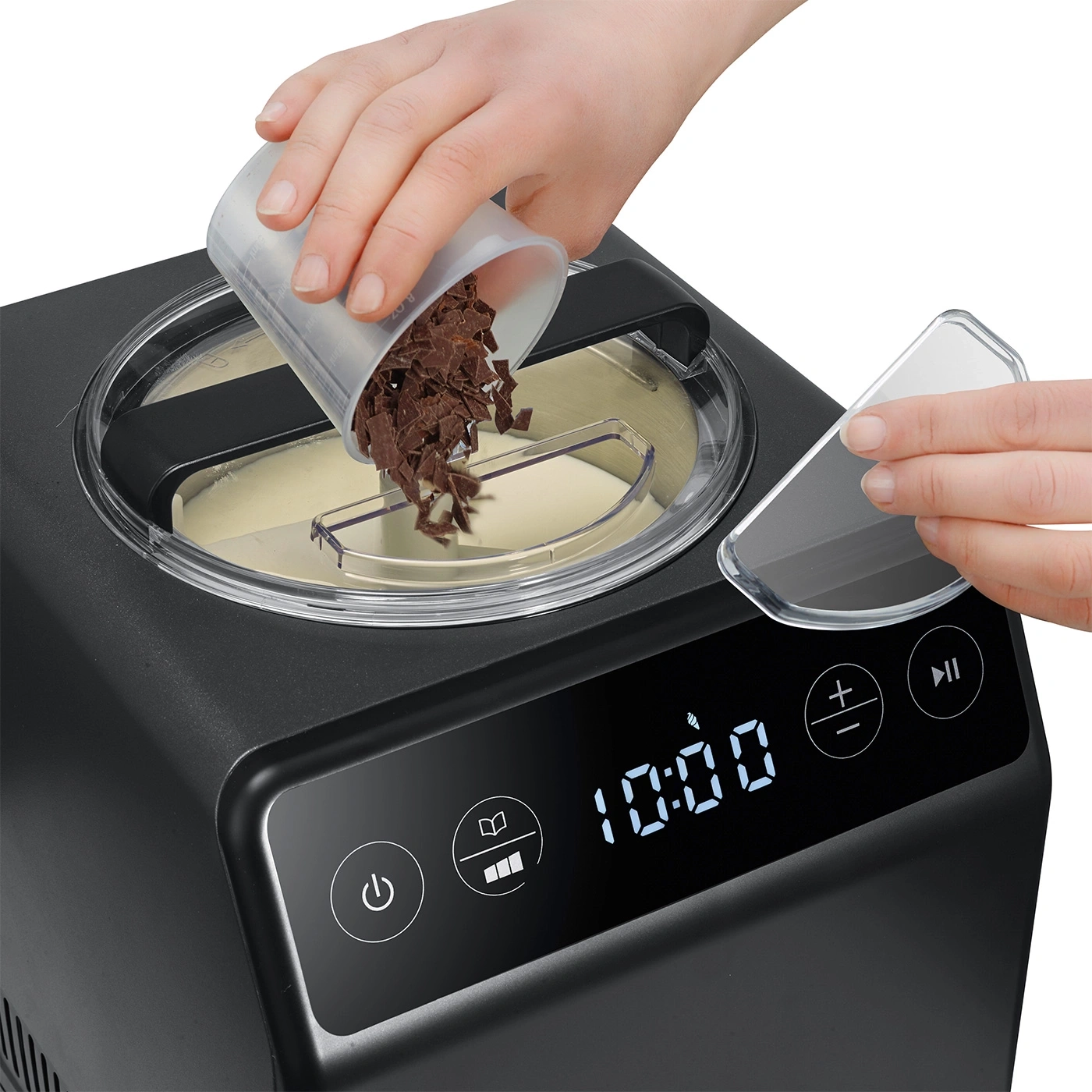 Personne versant des morceaux de chocolat dans une sorbetière. Machine noire avec écran.