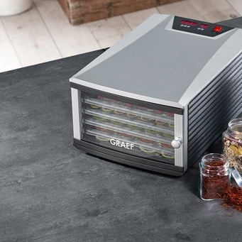 Close-up of a Graef food dehydrator with fruits on a table