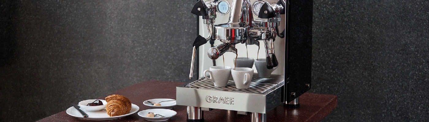 Machine à café avec croissant et pâtisseries sur une table