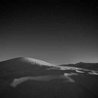 Nachtlandschaft mit Sternenhimmel und Dünen in Schwarzweißfotografie
