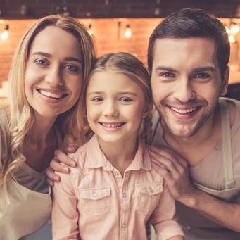 Familie lächelt in die Kamera, Mutter, Vater und Kind, glücklich
