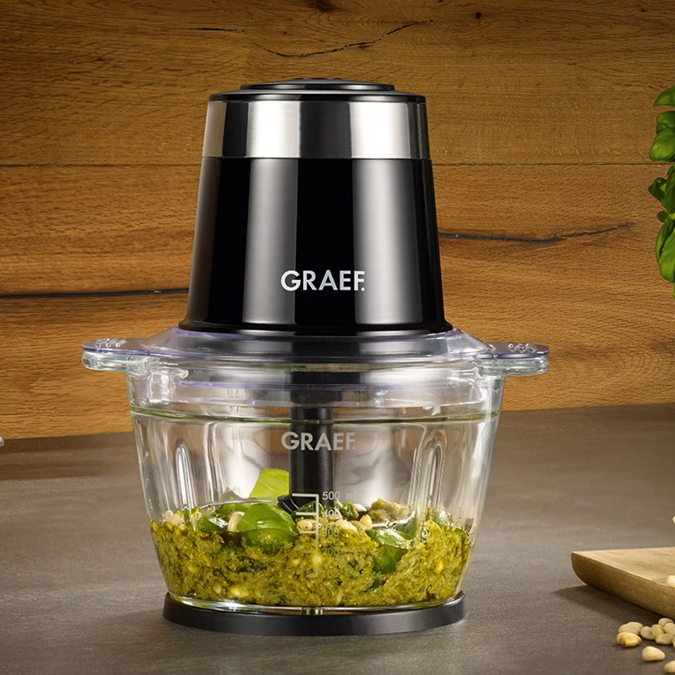 Graef food processor with pesto in glass container, close-up, wooden background