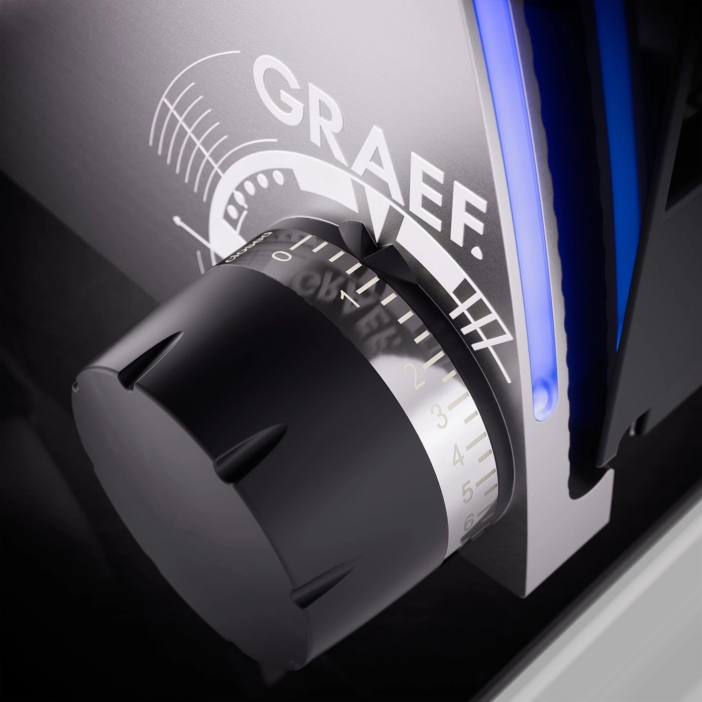 Close-up of a black dial with numbers and the brand name GRAEF on it.