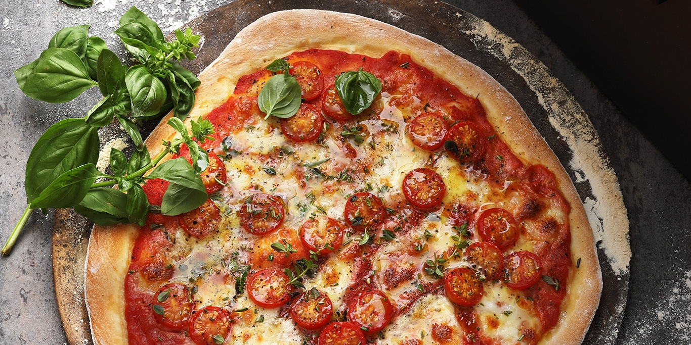 Pizza with tomatoes and basil, on a wooden board, delicious and fresh