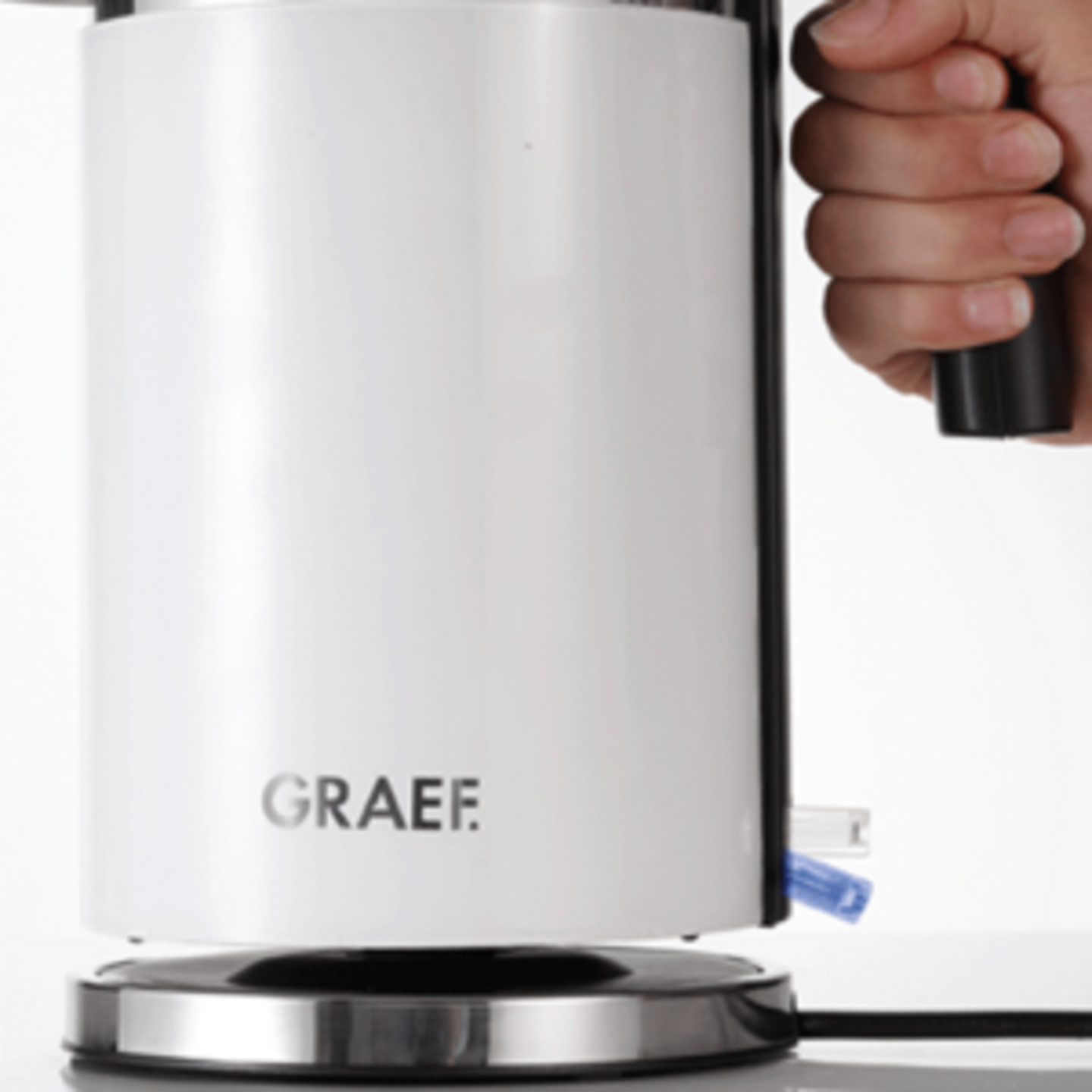 White GRAEF kettle on a silver base with a black handle, close-up shot.