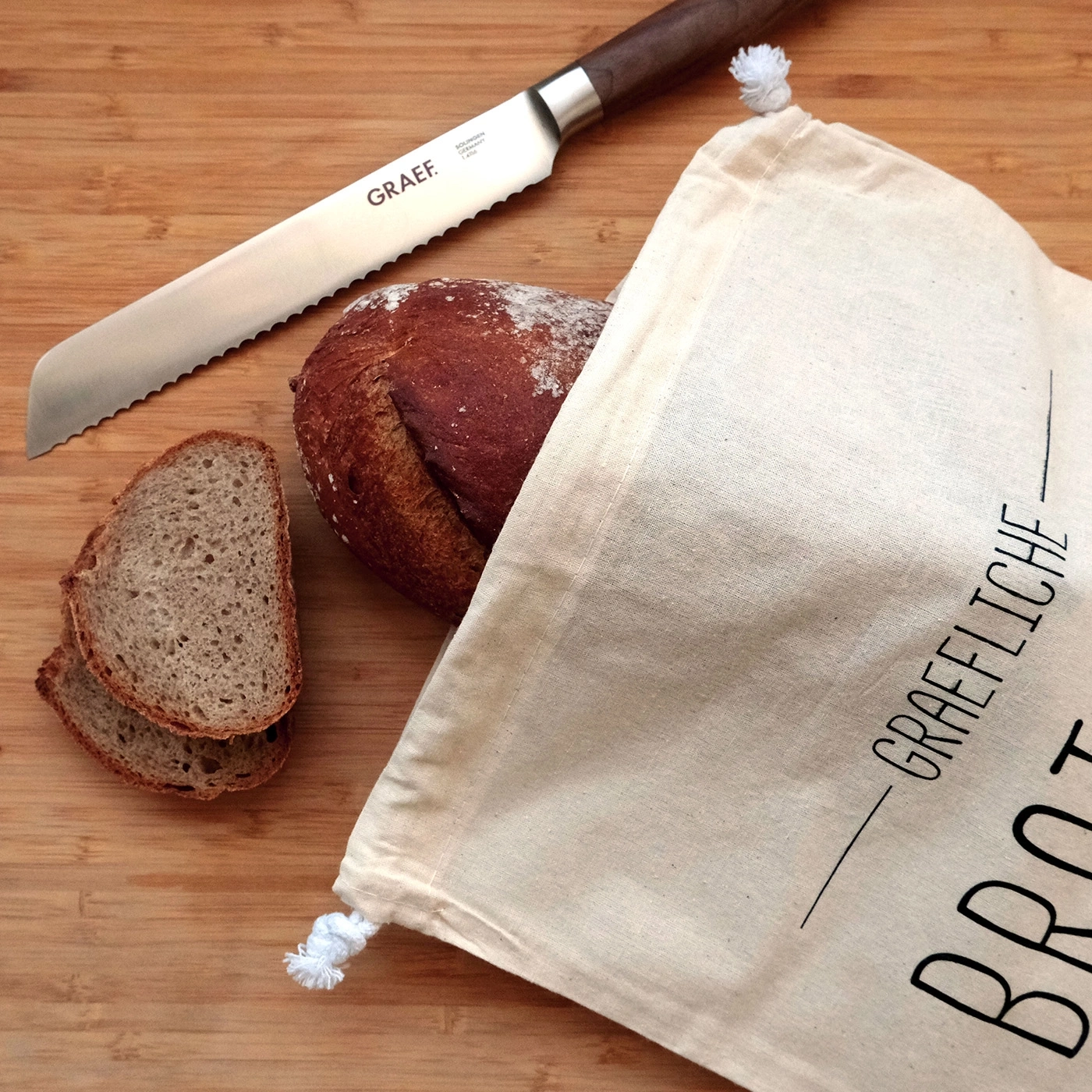 Brot, Messer und Beutel auf Holzbrett. Nahaufnahme.