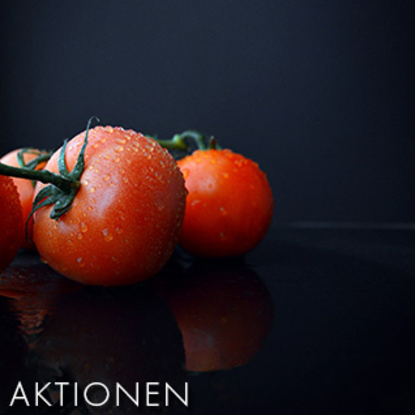 Nahaufnahme von Tomaten mit Wassertropfen auf schwarzem Hintergrund. Frische, rote Früchte.