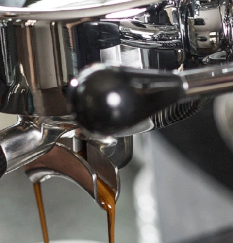 Gros plan d'une machine à expresso avec du café qui coule.