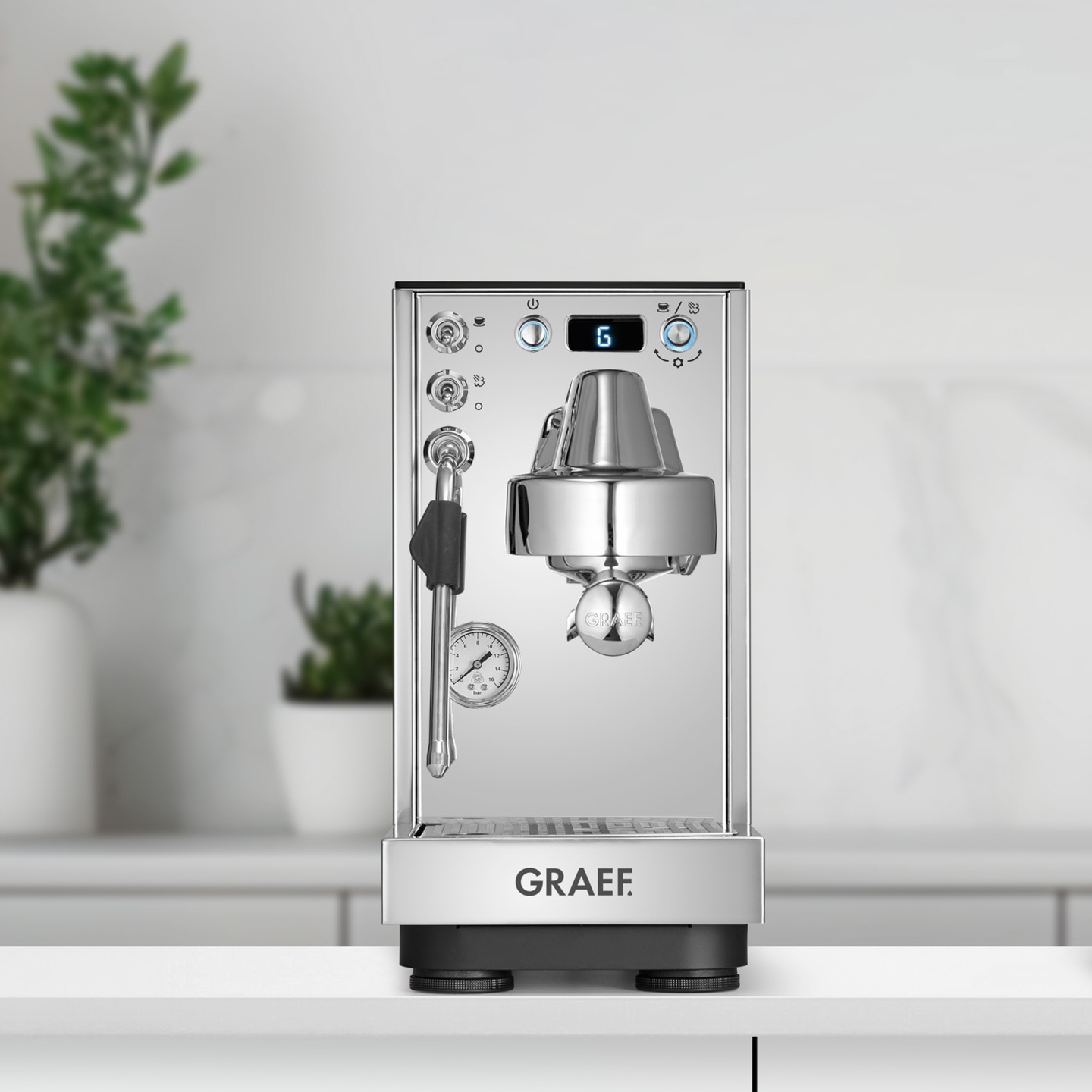 Eine glänzende Chrom-Espressomaschine von Graef mit digitalen Anzeigen und einem Dampfstab.