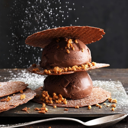 Chocolate ice cream with wafers and sprinkles, dusted with powdered sugar