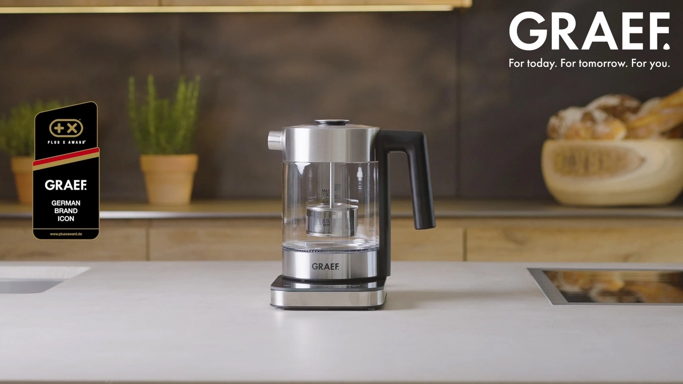 GRAEF kettle with award, German Brand Icon, on a kitchen counter with plants and bread.