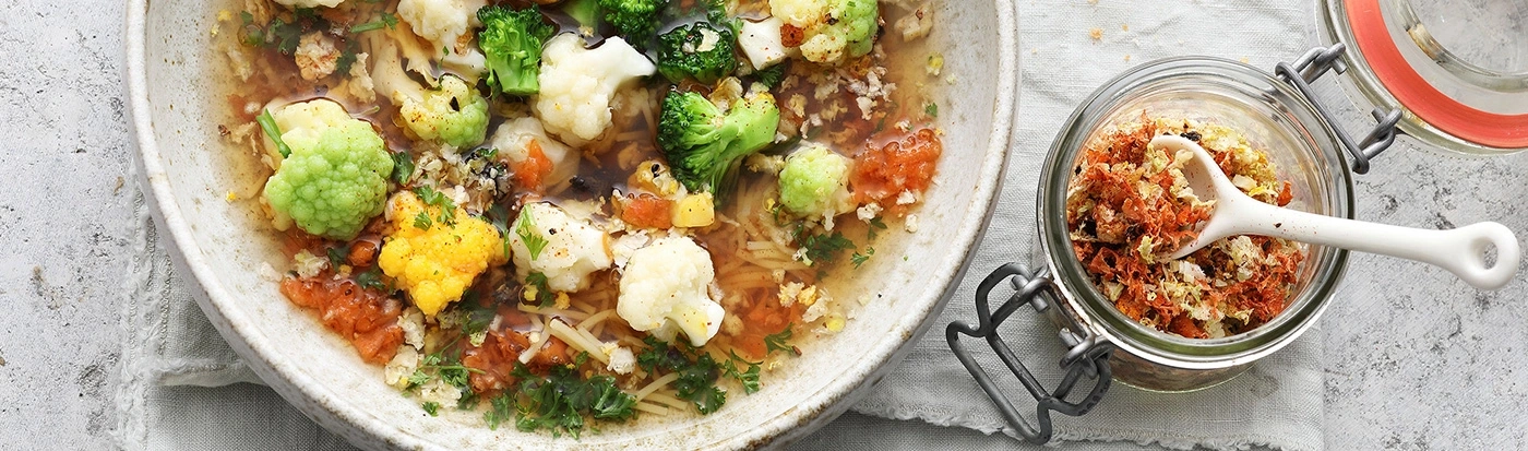 Gemüsesuppe mit Blumenkohl, Brokkoli und Gewürzen in einem Glas