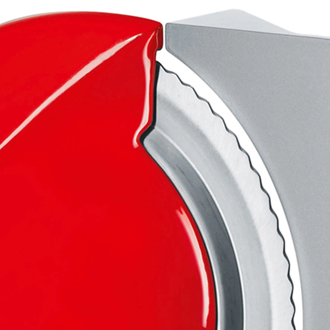 Gros plan d'un objet rouge avec une partie métallique dentelée et un fond gris