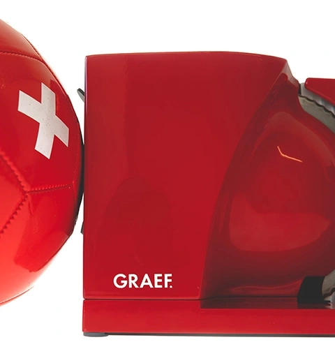 Ein roter Fußball mit Schweizer Kreuz auf einem roten Graef-Schneidegerät.