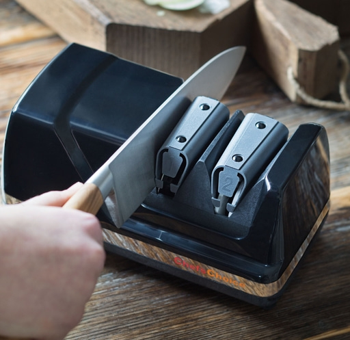 Messer wird mit einem schwarzen Messerschärfer geschärft, Nahaufnahme.