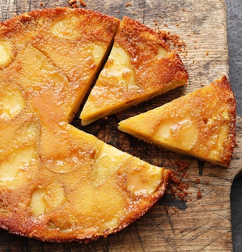 Ein köstlicher Apfelkuchen, der auf einem Holzbrett serviert wird, mit Stücken.