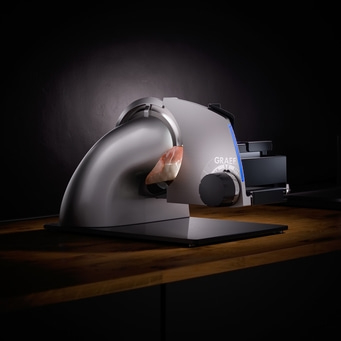 Graef Fleischschneidemaschine mit Fleisch auf Holzoberfläche