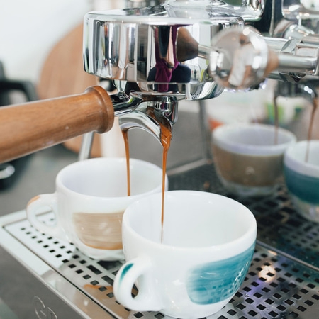 Espressomaschine, die Kaffee in Tassen gießt, Nahaufnahme, Kaffeegenuss, Getränk