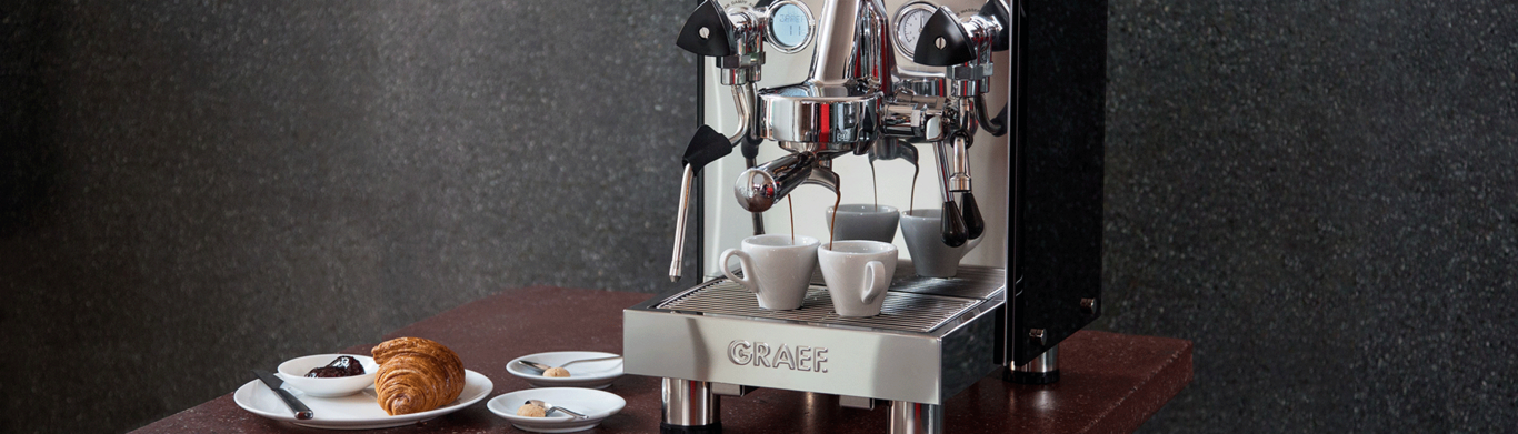 Coffee machine with croissant and pastries on a table