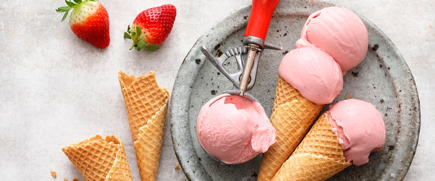Crème glacée à la fraise dans des cornets avec des fraises sur une assiette