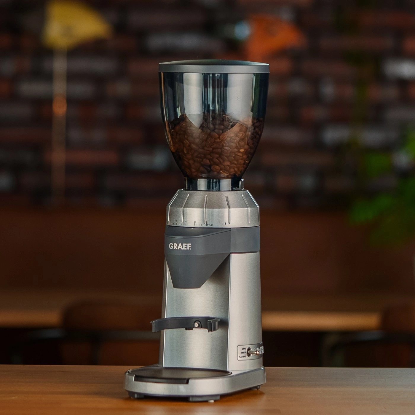 Kaffeemühle mit Bohnen auf einem Holztisch, GRAEF-Marke, Nahaufnahme