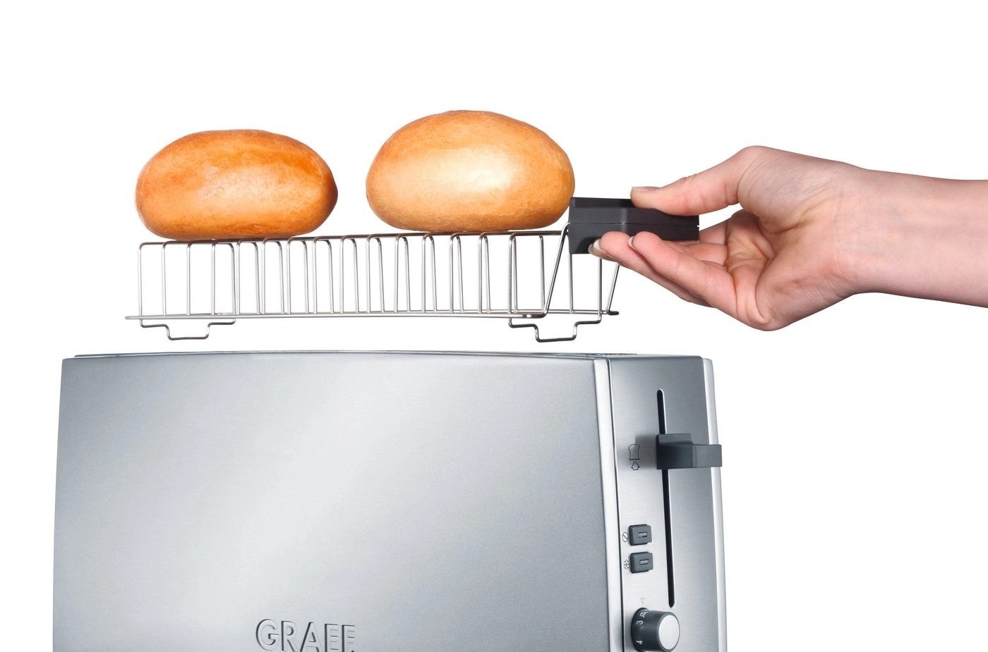 Toaster mit Brötchen und Hand, die einen Einsatz hält.