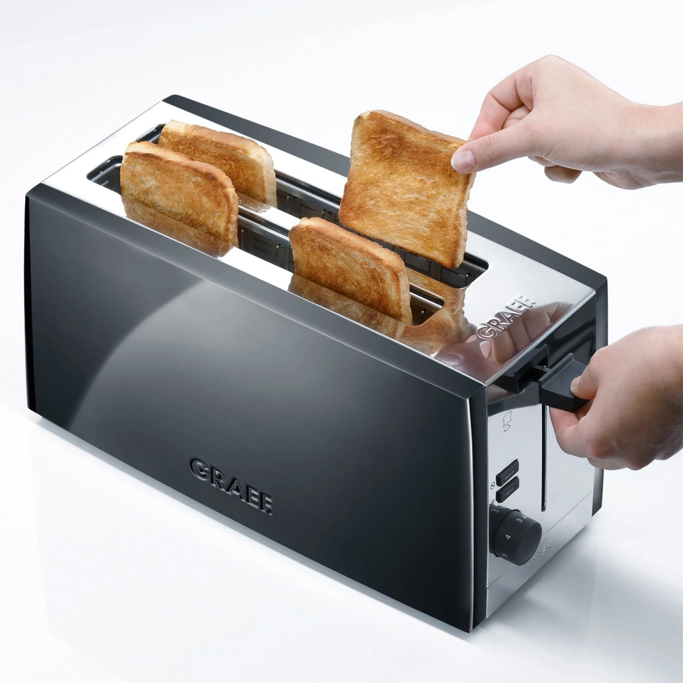 Ein Toaster mit Toastbrot, das aus dem Toaster genommen wird, Nahaufnahme.