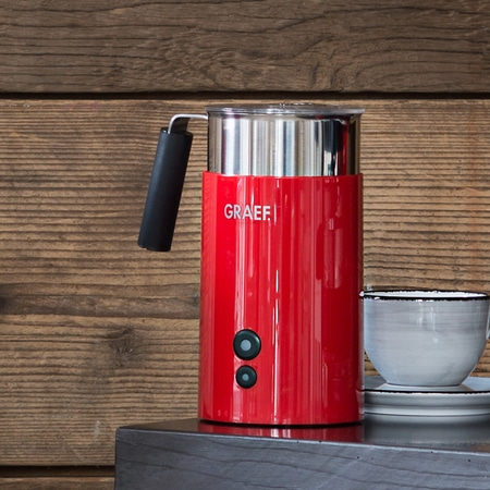 Mousseur à lait rouge avec tasse sur table en bois, logo GRAEF