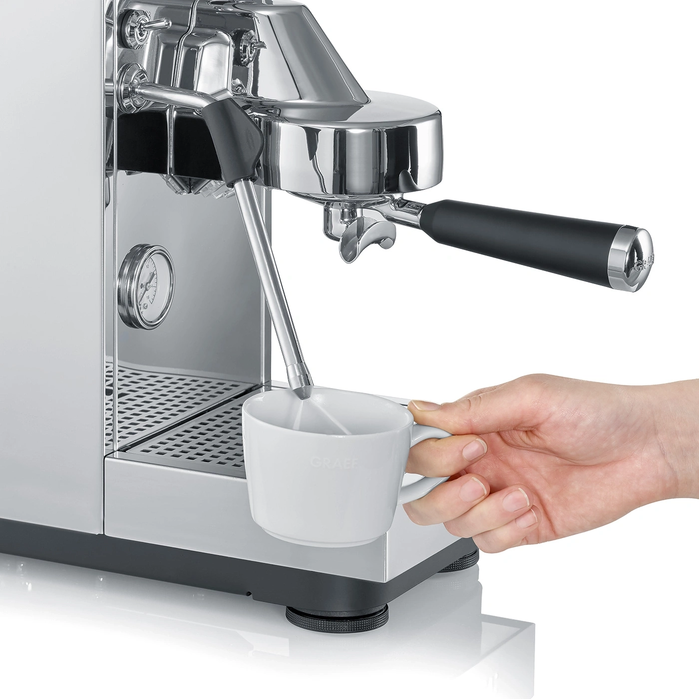 A hand holds a coffee cup under an espresso machine.