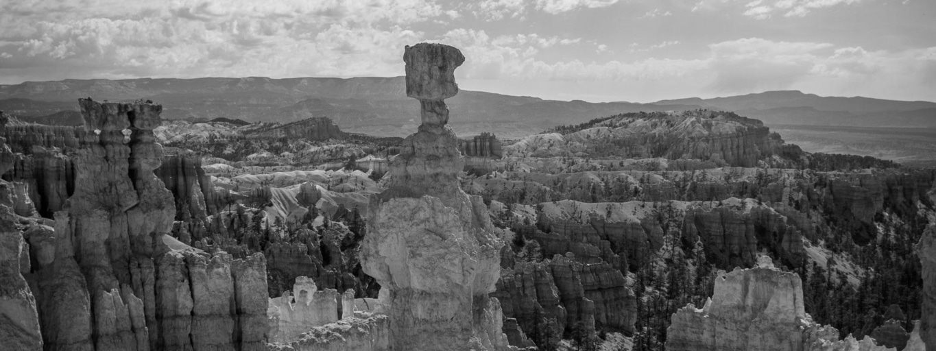 Graustufen-Landschaft mit Felsformationen und Wolken am Himmel, Naturwunder.