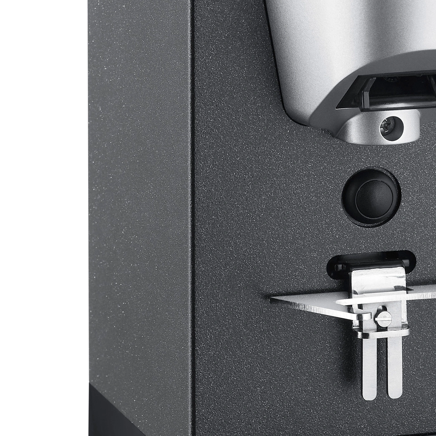 Gros plan d'un appareil noir avec un bouton et une pièce métallique
