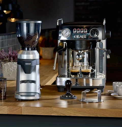 Kaffeemaschine und Kaffeemühle auf Holzoberfläche. Espresso zubereiten.